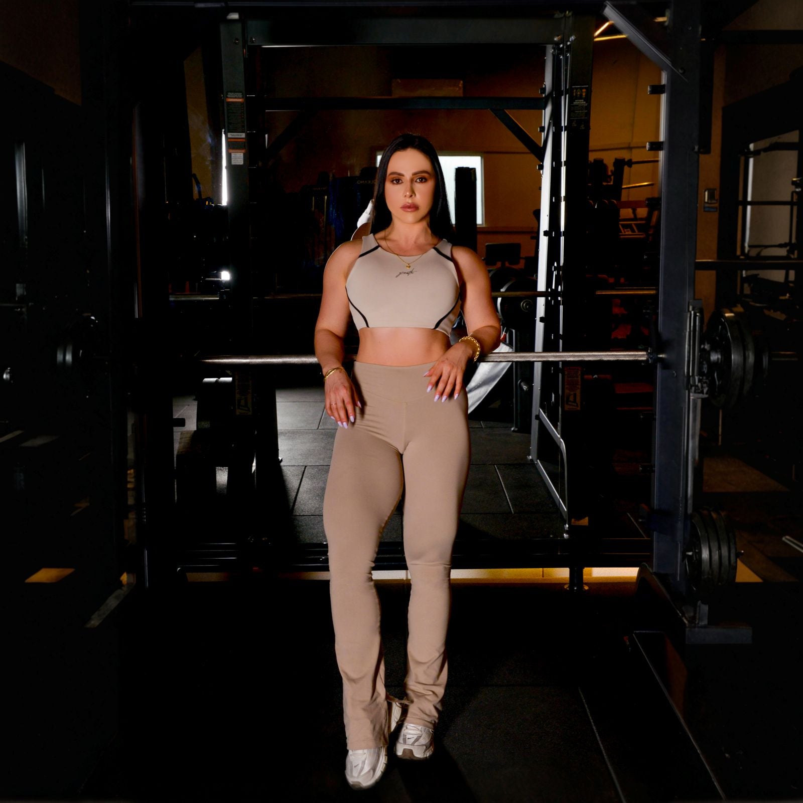 Daiane Freitas em pé diante do rack de agachamento