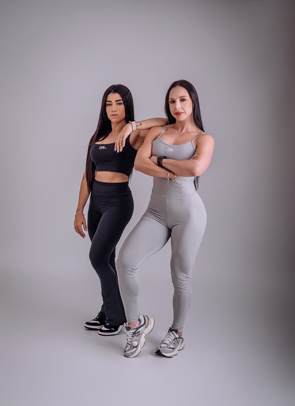 Duas personal trainers posando em ensaio de estúdio com roupas DF Fit